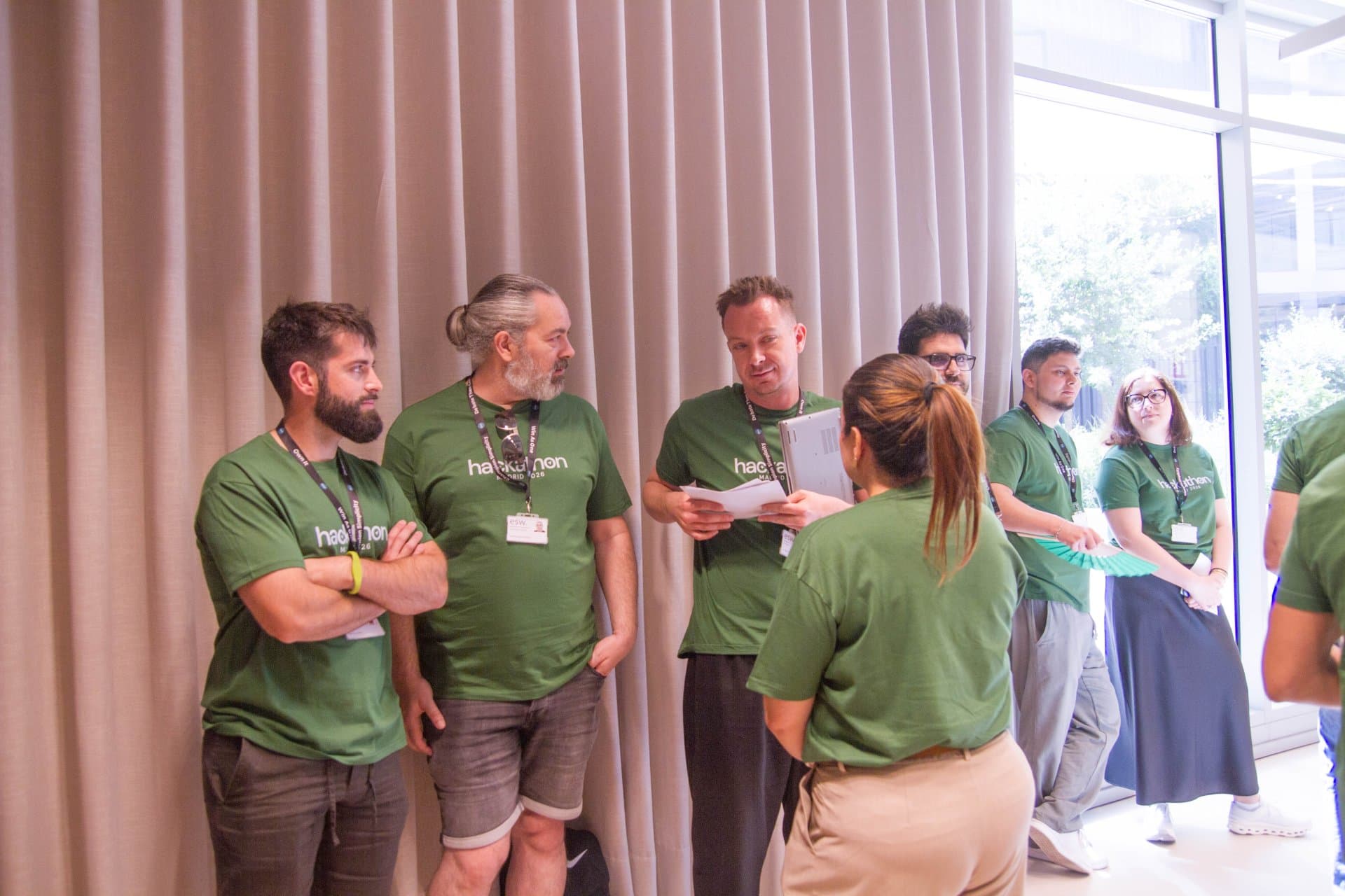 Hackathon teams planning their strategy in their Hackathon merch T-shirts.